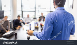Guy leading meeting around large conference table